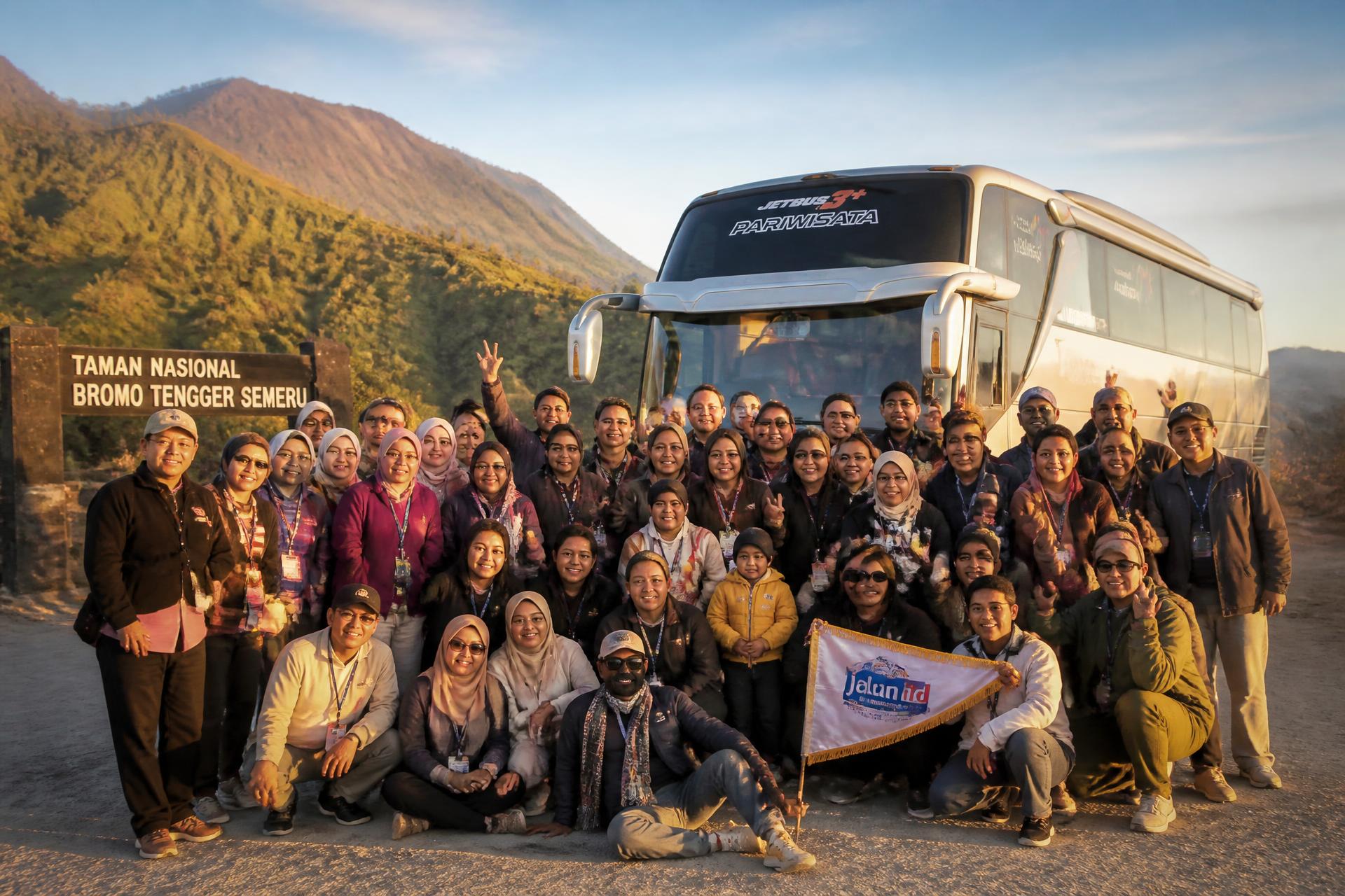 Rombongan wisata Ratuna Travel berfoto bersama di depan bus pariwisata